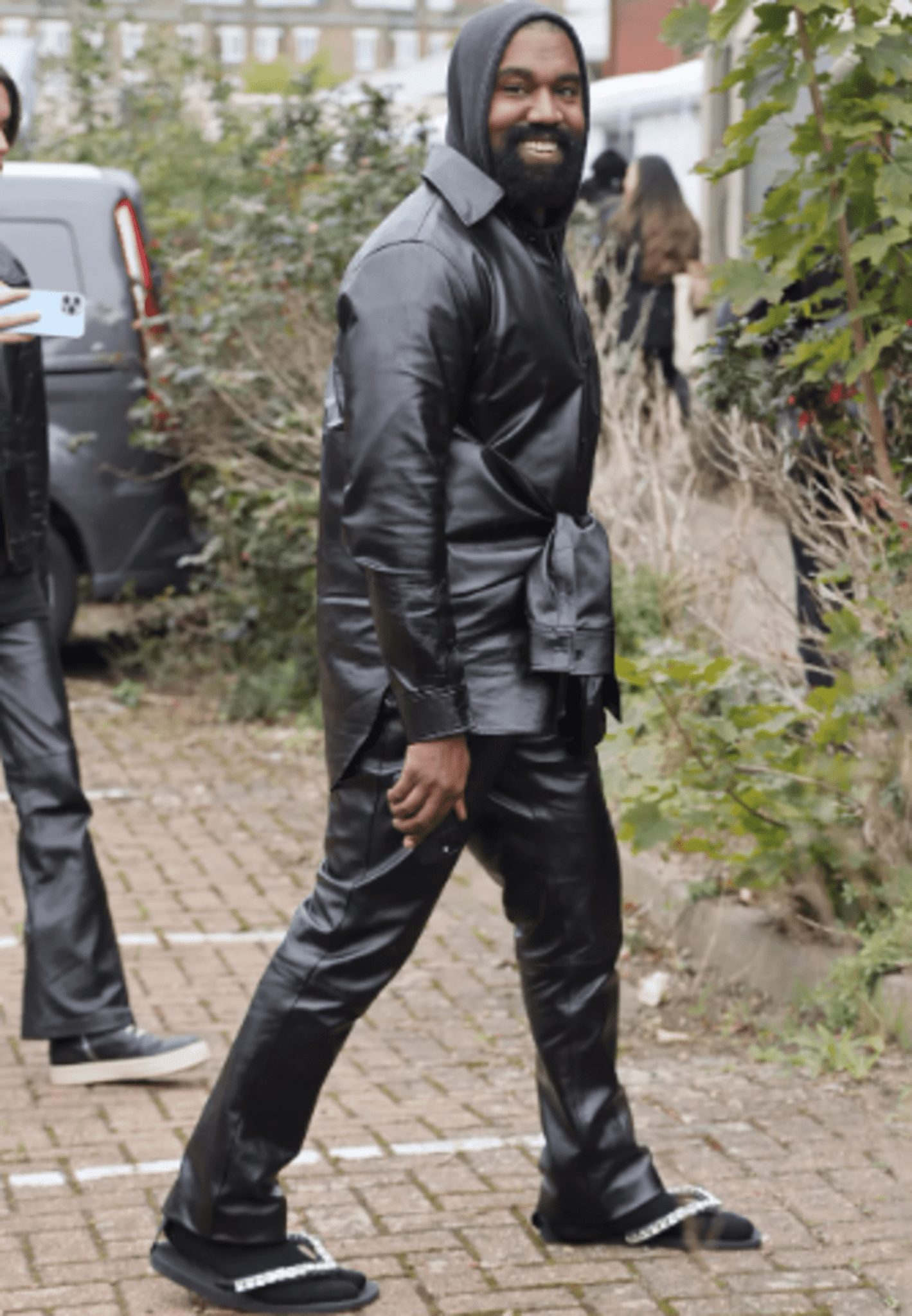 Wearing Sparkly Flip Flops And Socks, Kanye West Attends The Burberry Show